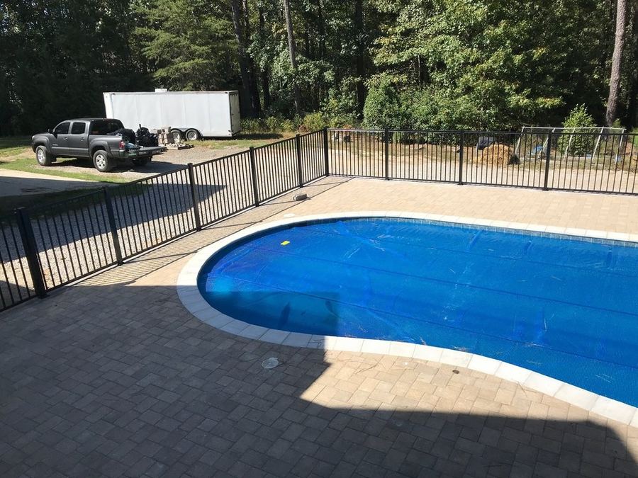 Black aluminum pool fence with self-closing gate in Durham NC