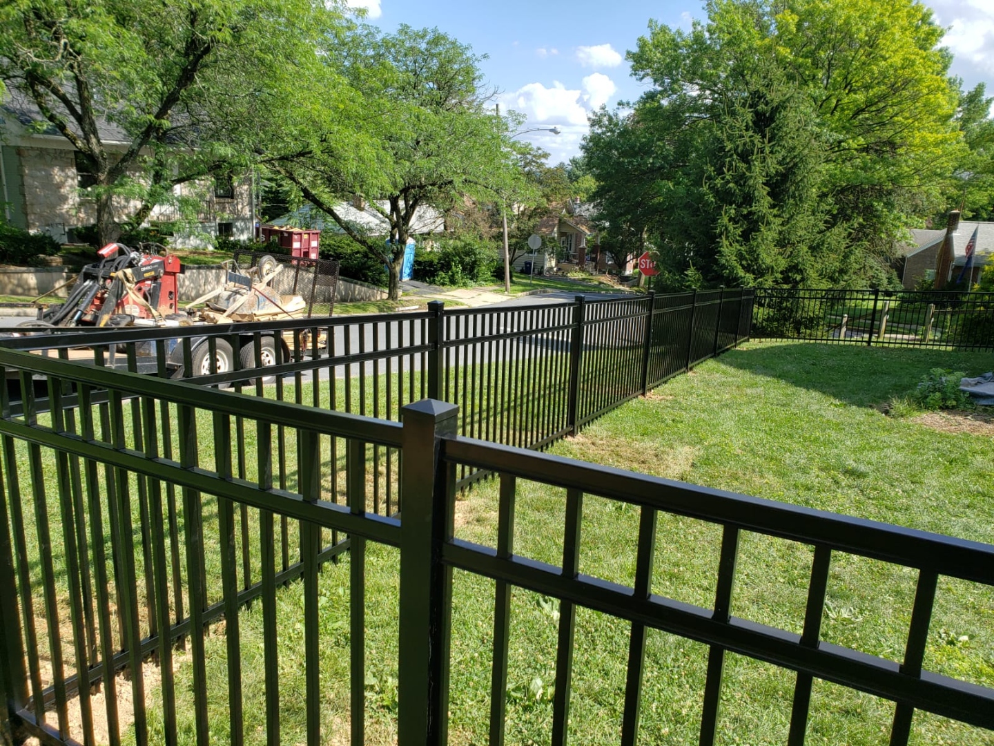 Black aluminum fence wrapping around a residential corner lot