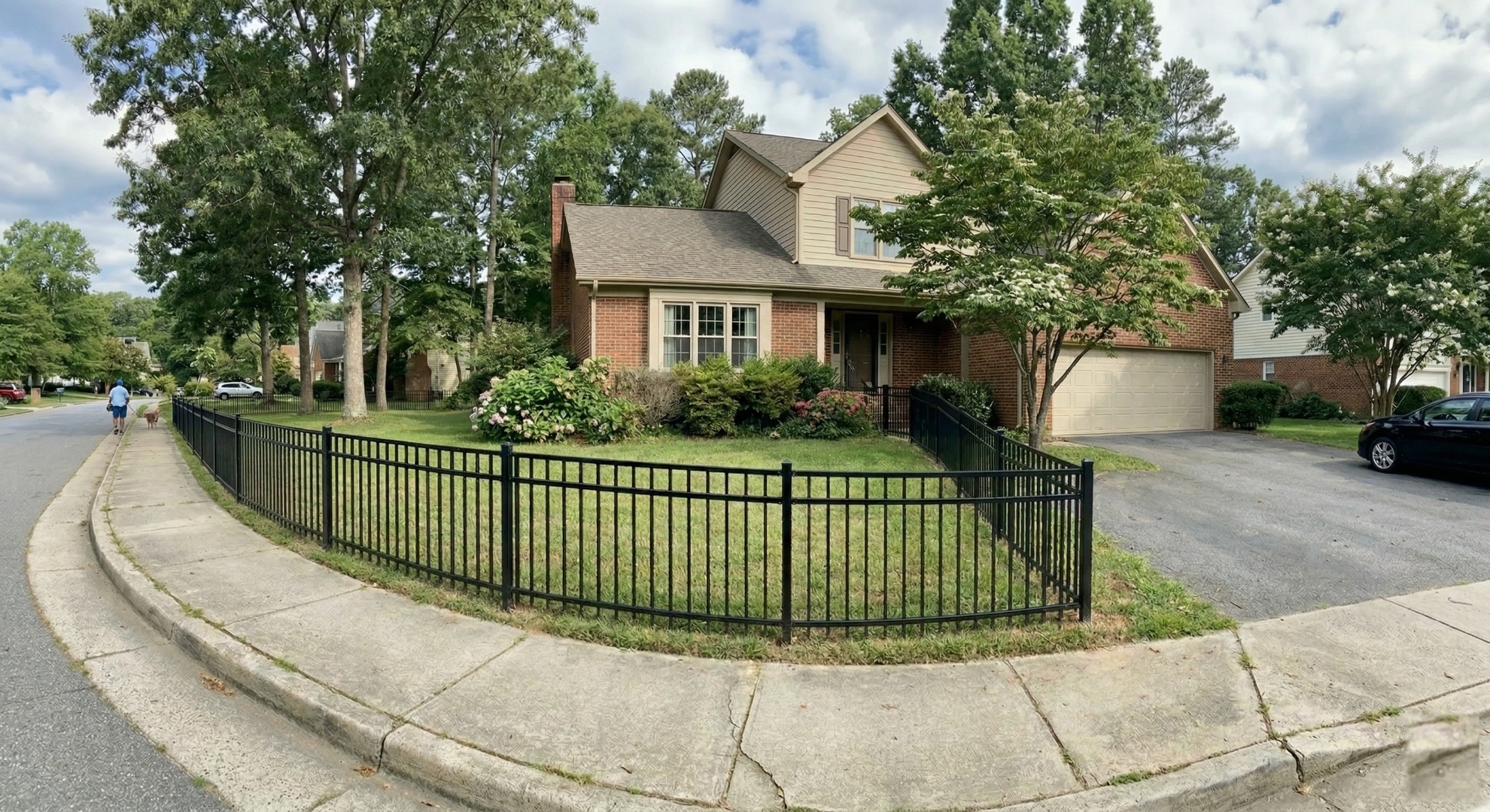 Black aluminum fence curving around a residential corner lot in a Triangle NC neighborhood