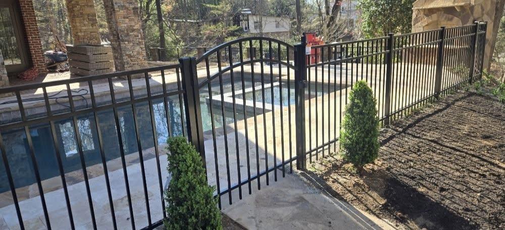 Black aluminum pool fence with self-closing gate in Durham NC