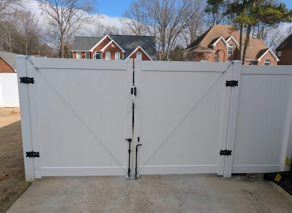 Wide white vinyl double drive gate with black hardware in a Triangle NC neighborhood