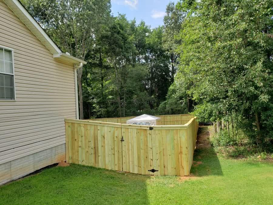 Wood cap and trim fence enclosure with walk gate in a Triangle NC backyard