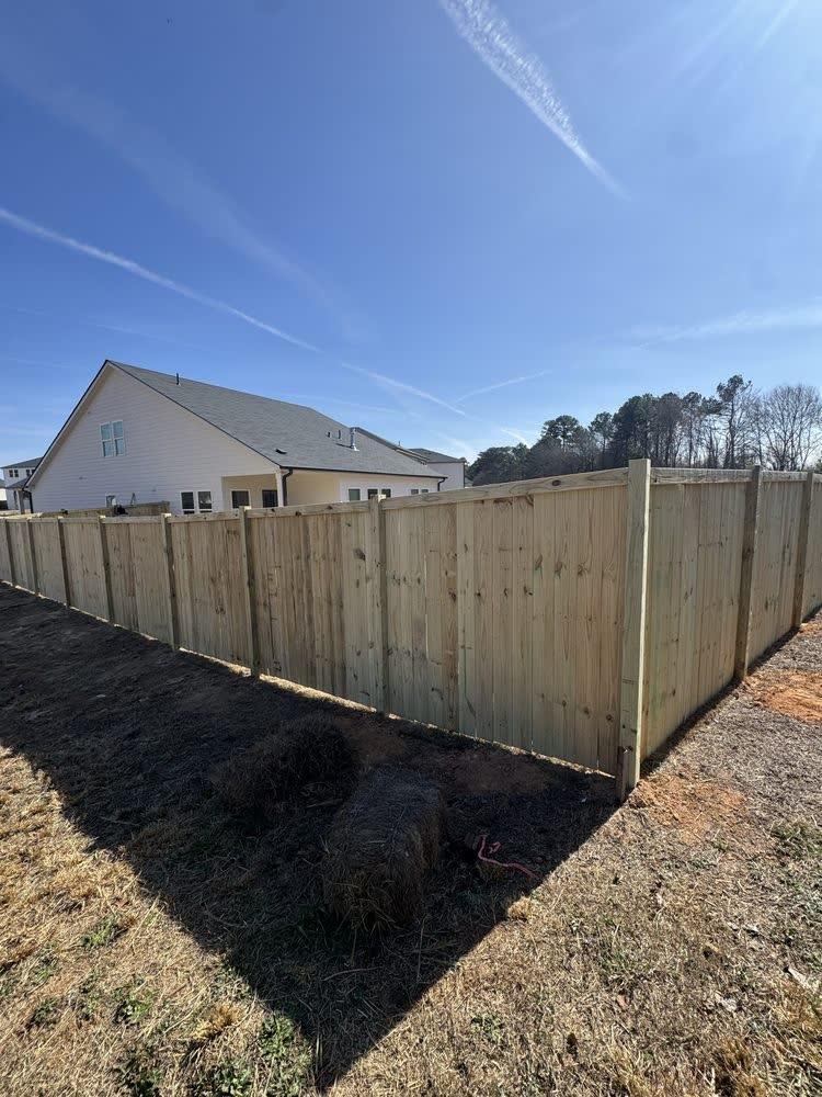 Wood cap and trim privacy fence with round ball post caps in a Triangle NC backyard