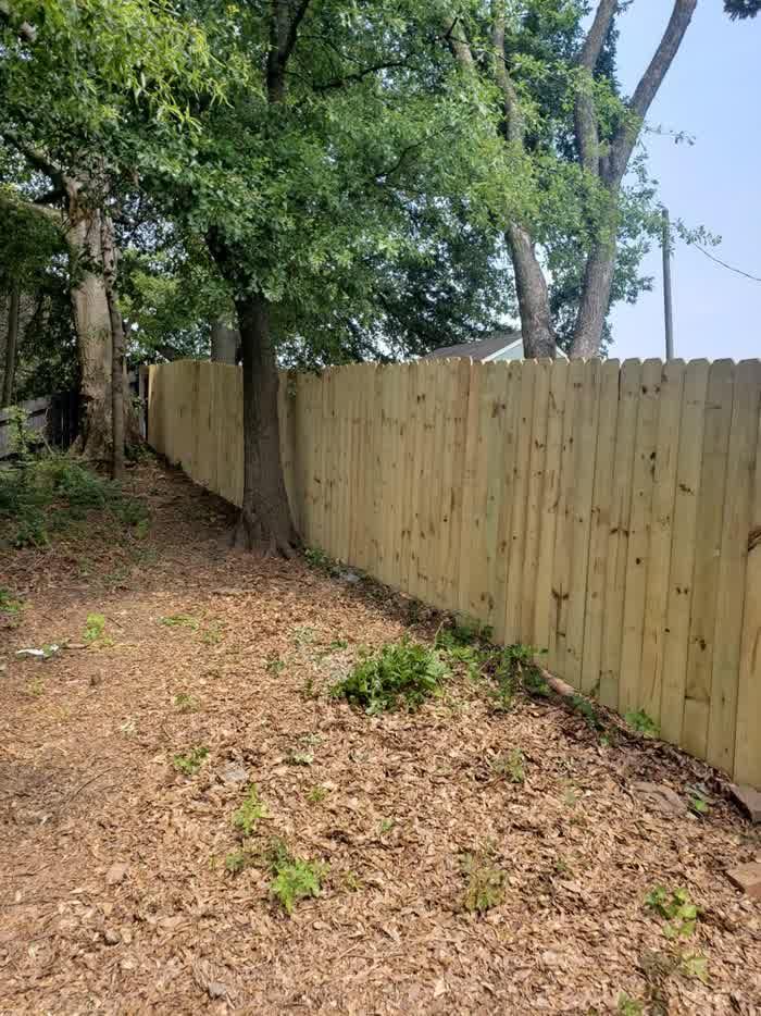 Dog ear wood privacy fence racked along a sloped yard in Durham NC