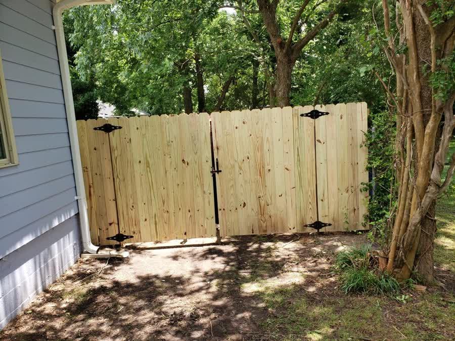 Double drive wood gate on a privacy fence in a residential North Carolina backyard
