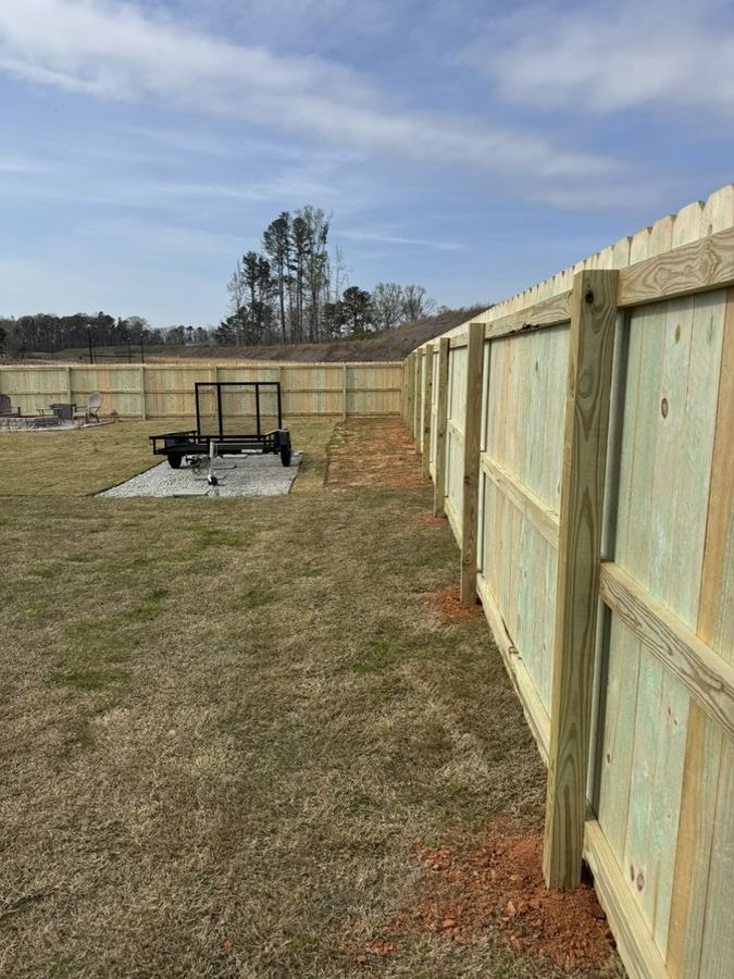 Inside view of a new wood privacy fence installation in a suburban NC backyard